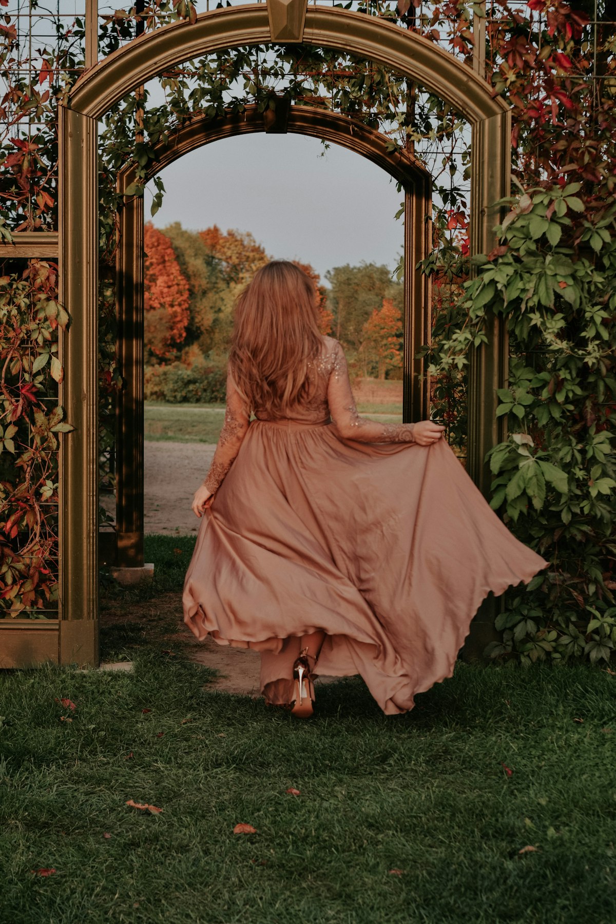 Dusted rose silk dress under garden archway, morning in Florence